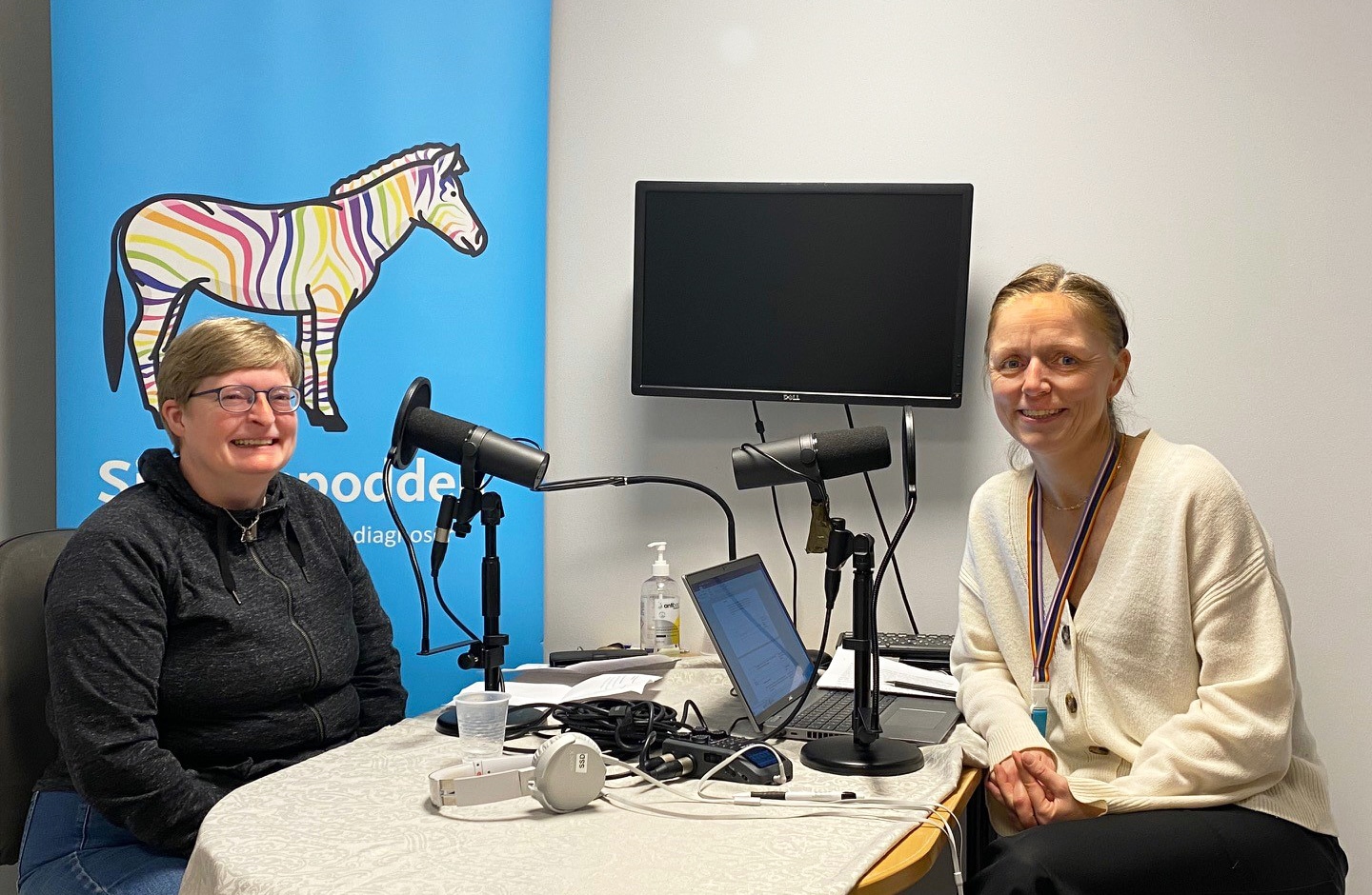To personer sitter i et podcaststudio. Foto.